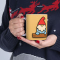 Person holding a mug with a gnome design, wearing a dark sweater 