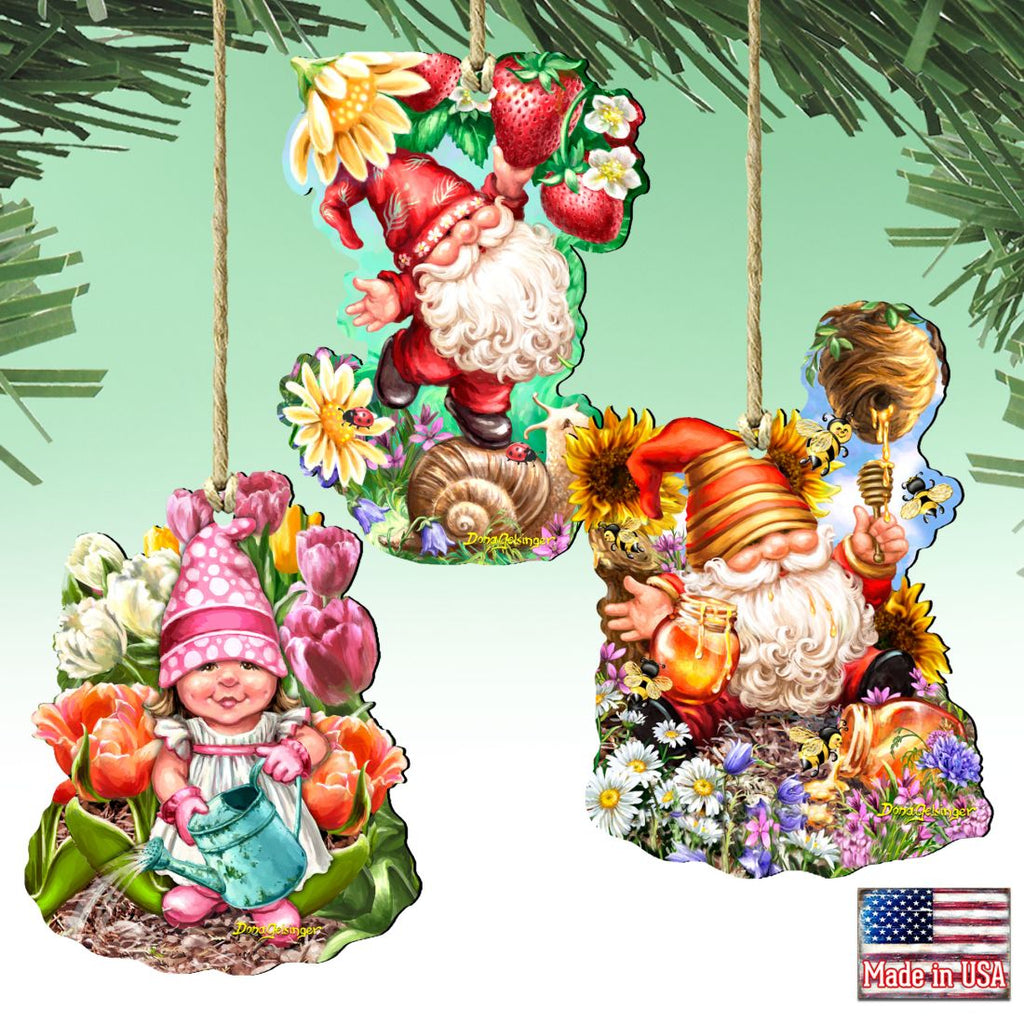 Three hanging gnome ornaments with flowers, strawberries, a watering can, honey and bees.