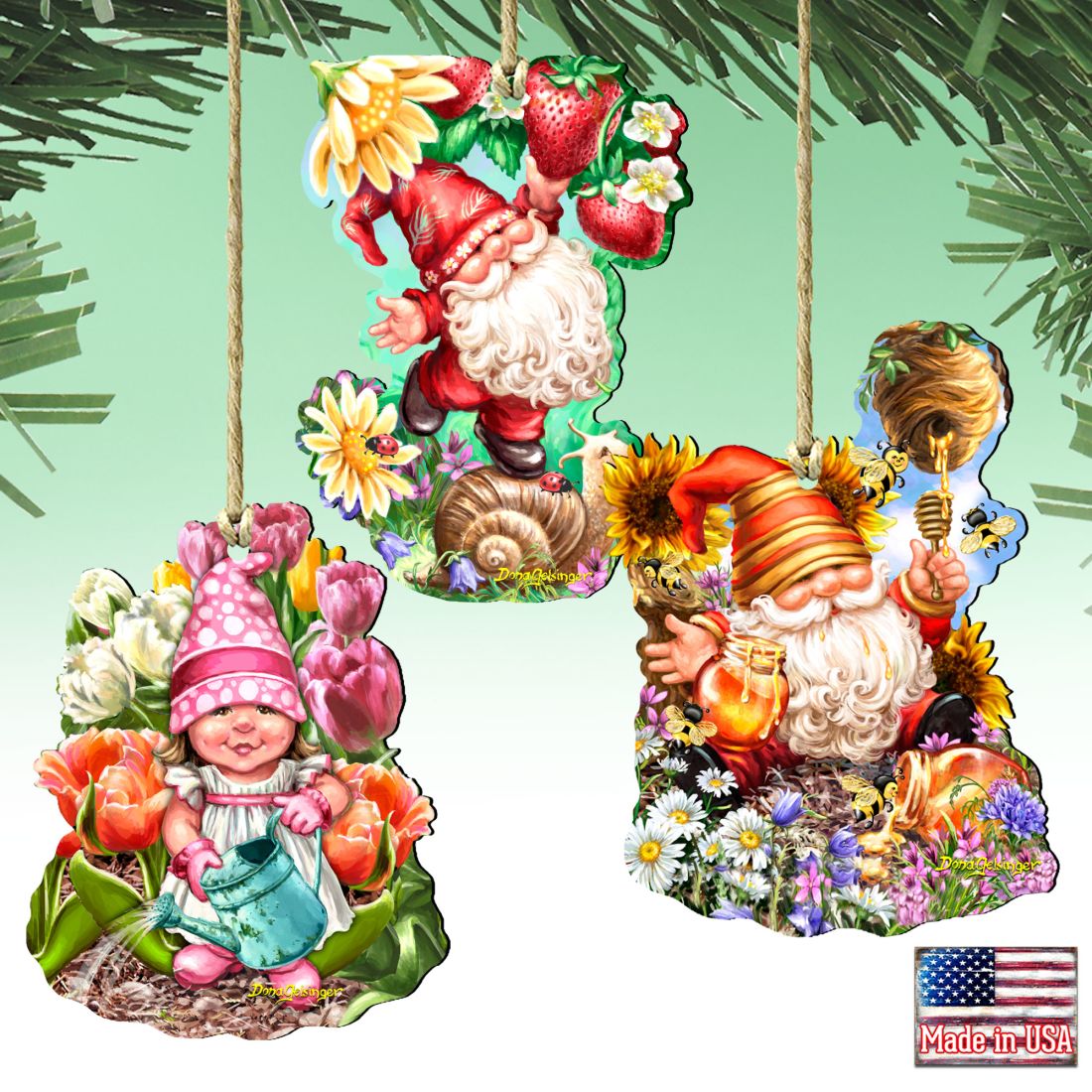 Three hanging gnome ornaments with flowers, strawberries, a watering can, honey and bees.