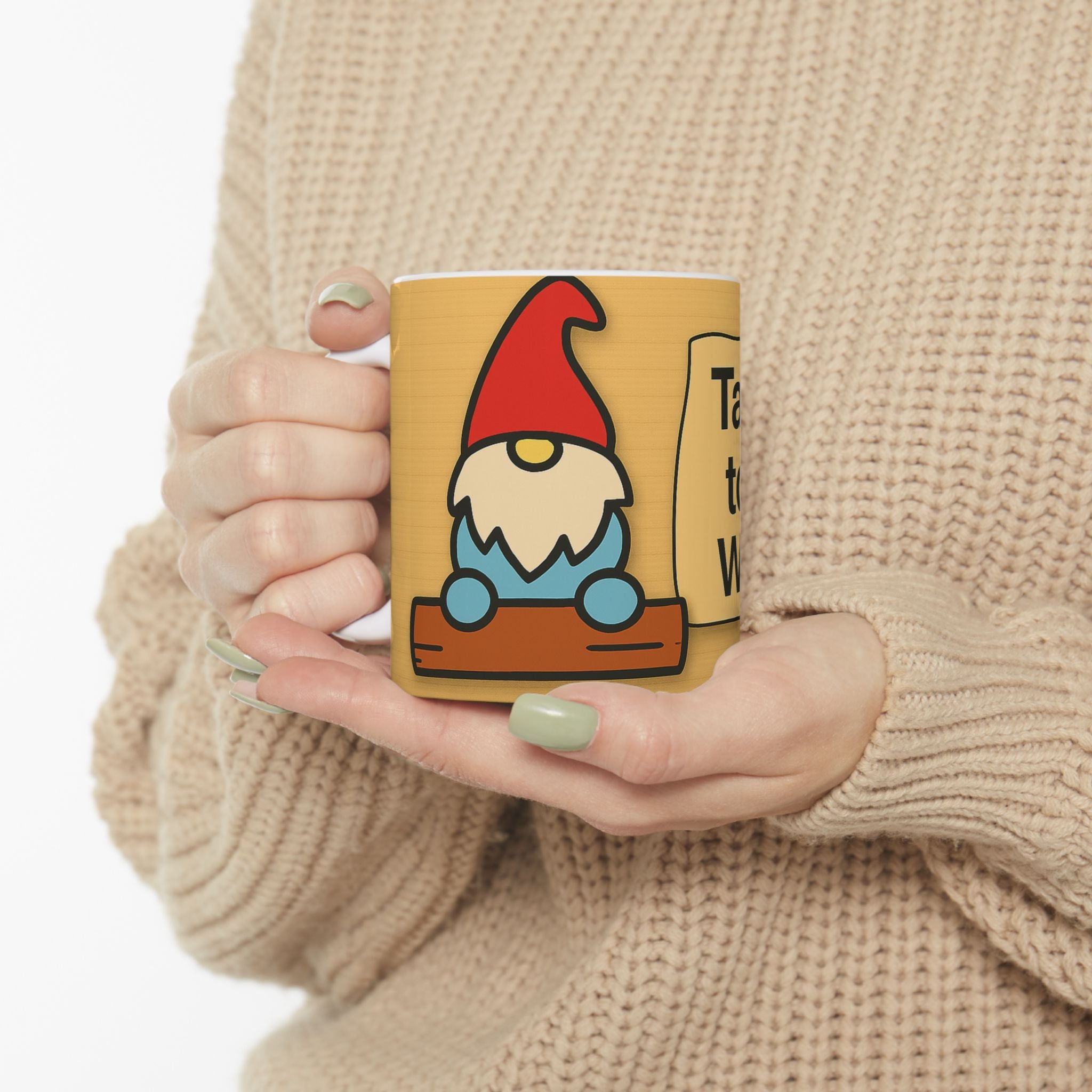 Person holding a mug with a gnome design against a beige background