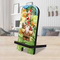 Tabletop phone stand with a tall berry-and-bird-hatted gnome holding two birds, illustrated against a green landscape.