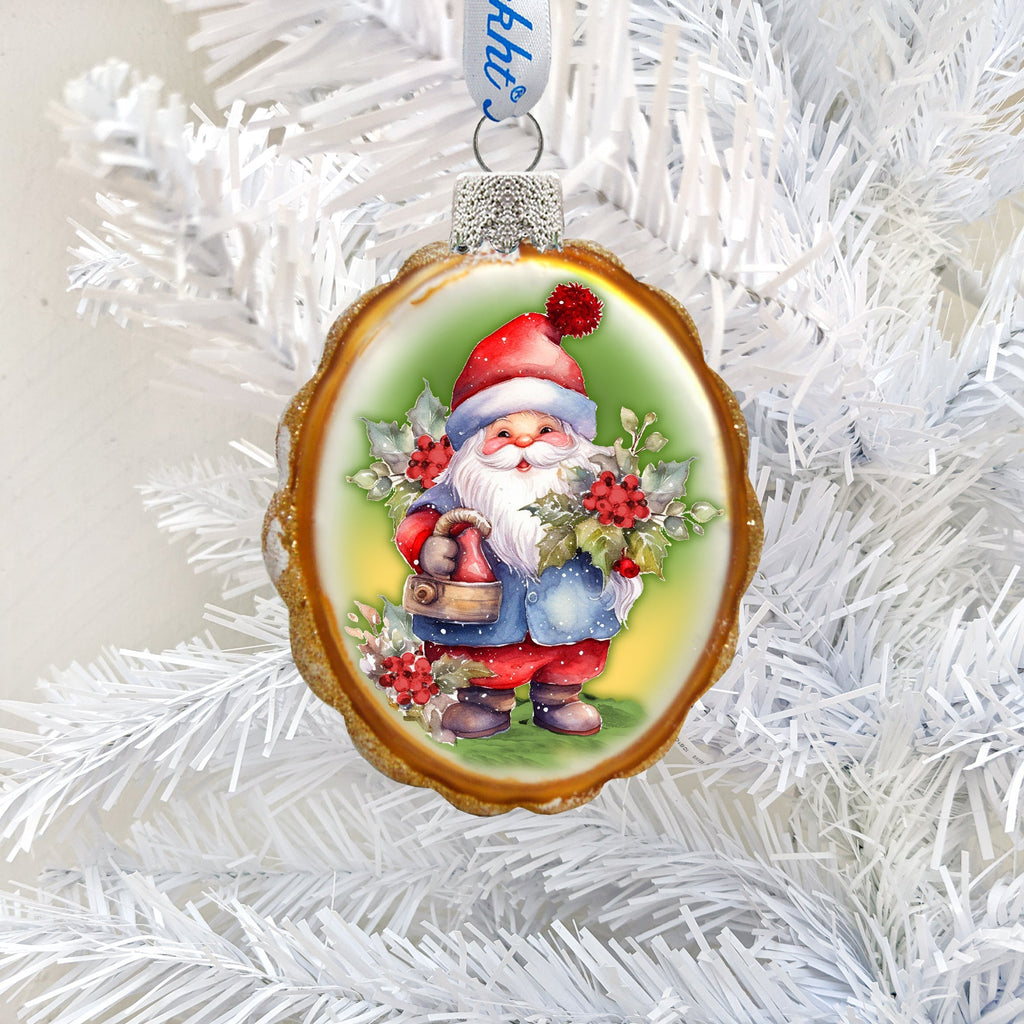 Oval Christmas ornament with a gold-colored edge depicting a red-hatted gnome holding holly and a bell.