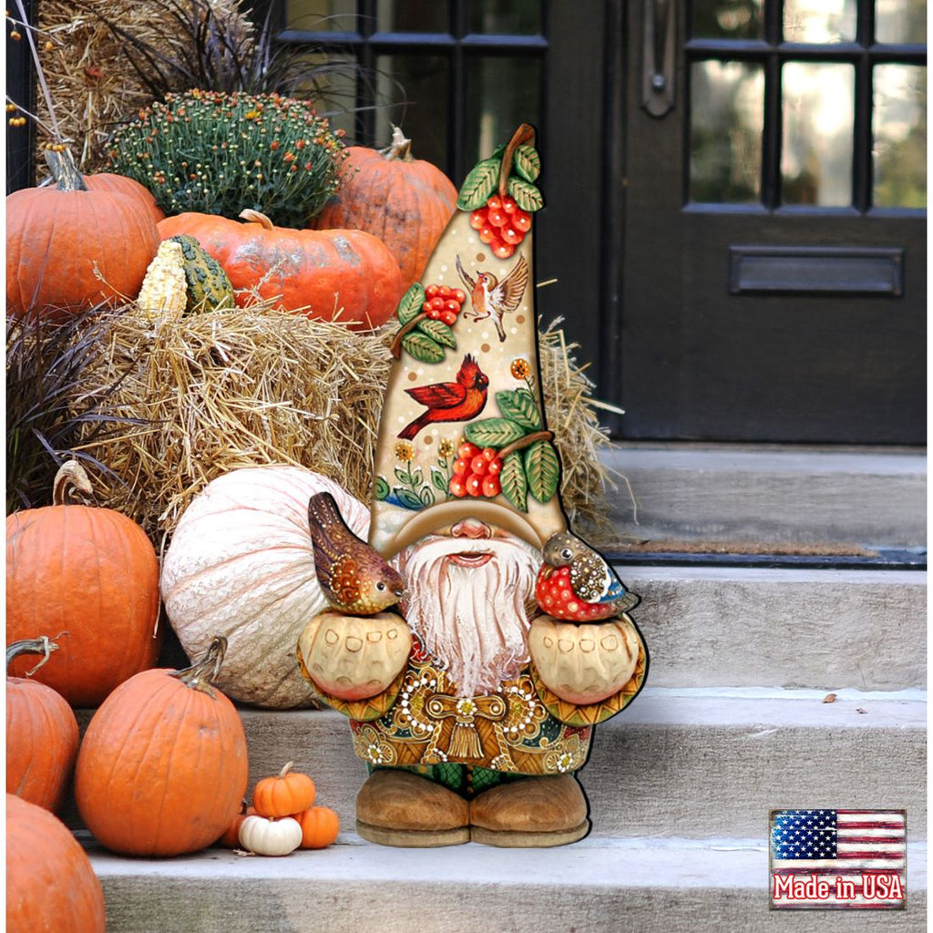 Fall gnome door decoration with a berry-and-bird hat and two birds, displayed on porch steps among pumpkins and straw.