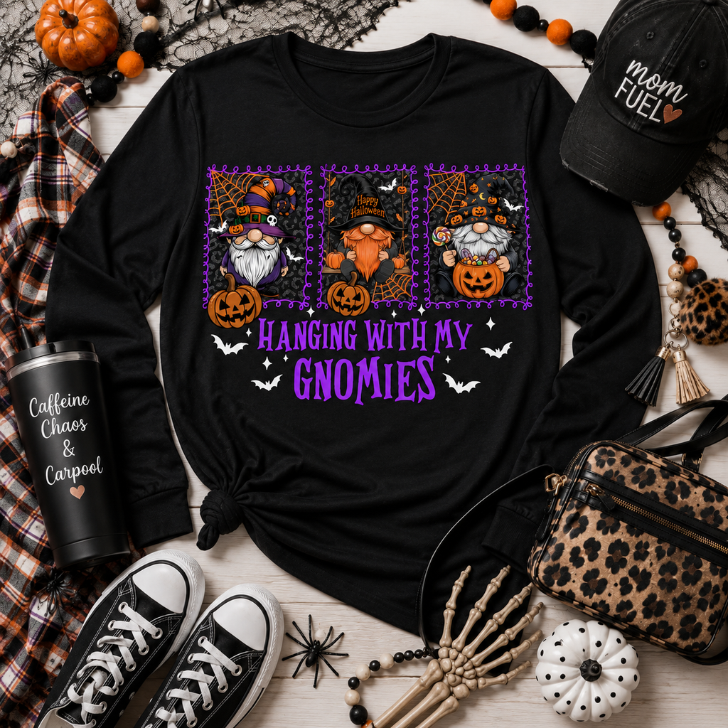 Black shirt with three Halloween gnomes, pumpkins, bats and purple Hanging With My Gnomies lettering in a styled flat lay.