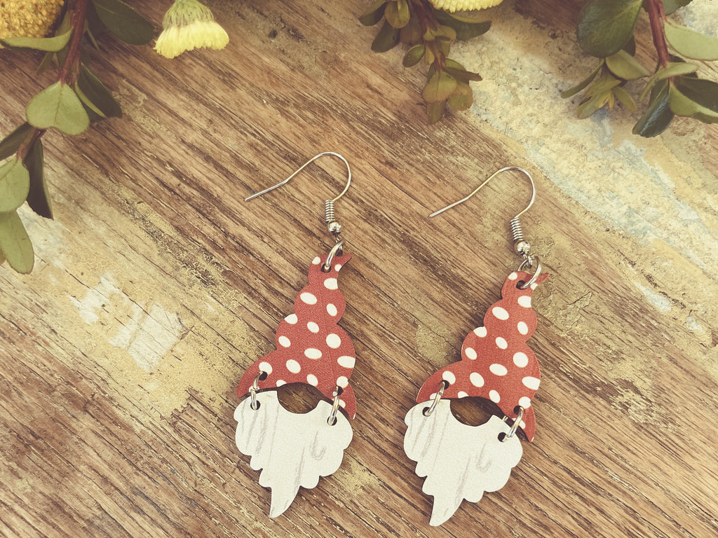 Pair of dangling gnome earrings with red polka-dot hats and articulated white beard pieces.