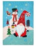 Blue winter garden flag with a red-hatted gnome, lantern, snowman, squirrel and snow-covered trees.
