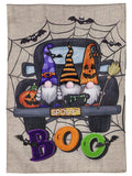 Garden flag with three Halloween gnomes in a truck marked SPOOKY, surrounded by spiderwebs, bats and colorful BOO letters.