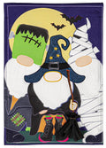 Purple Halloween garden flag with Frankenstein, witch and mummy gnomes beneath a yellow moon and bats.