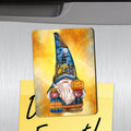 Refrigerator magnet depicting a blue-hatted Halloween gnome with a pumpkin and moonlit haunted-house artwork.