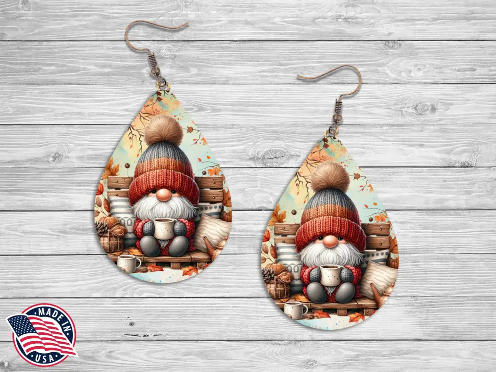 Pair of teardrop earrings printed with an autumn gnome holding a mug while seated on a wooden bench.