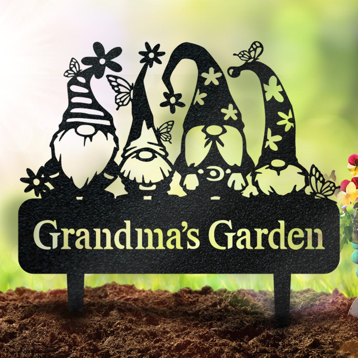 Black metal garden sign with four gnomes, flowers and butterflies above the words Grandma's Garden.
