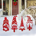 Four red metal Christmas gnome yard stakes with patterned hats and festive details displayed in snow.
