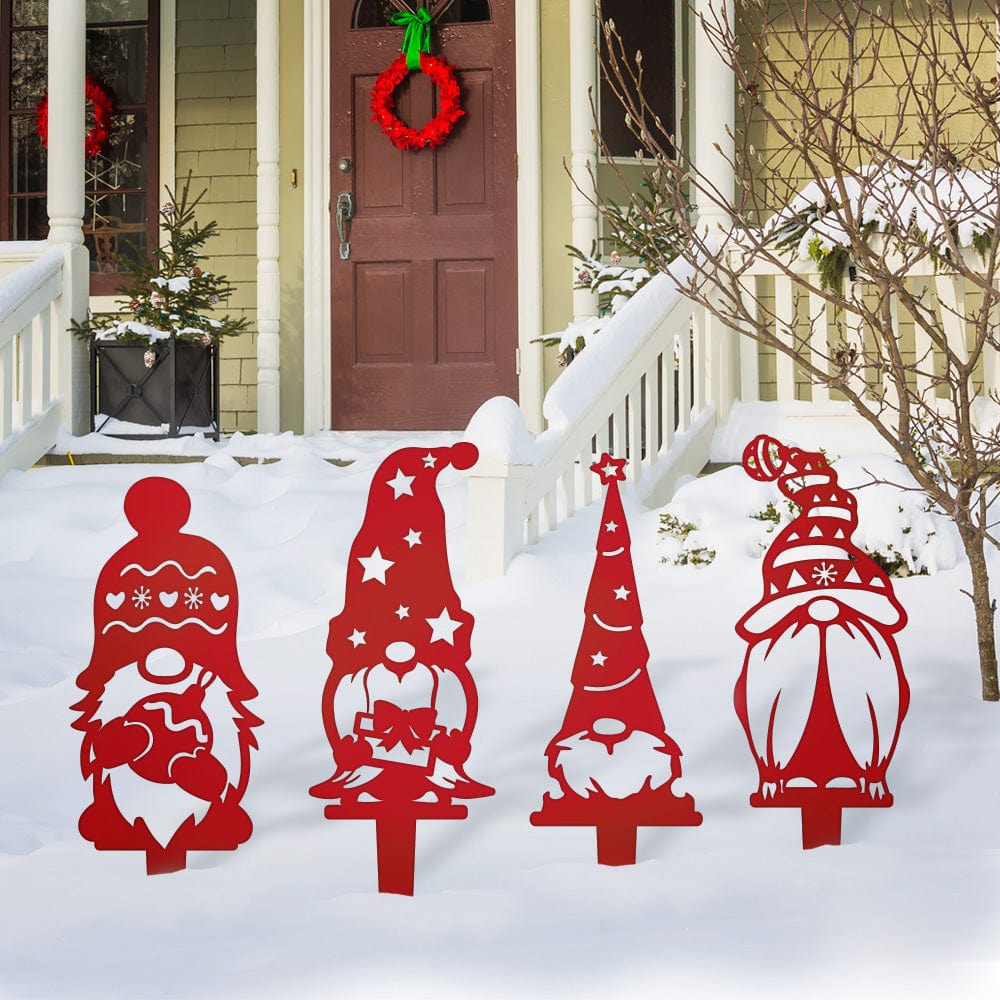 Four red metal Christmas gnome yard stakes with patterned hats and festive details displayed in snow.