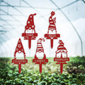 Red gnome-shaped garden markers labeled Corn, Bean, Cilantro, Carrot and Eggplant, with patterned hats.