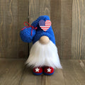 Gnome with blue hat and red shoes against a wooden background