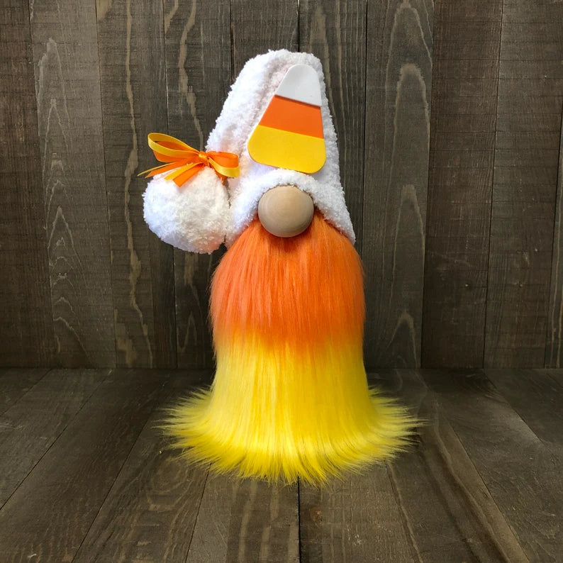 Decorative gnome with candy corn hat and beard on a wooden background