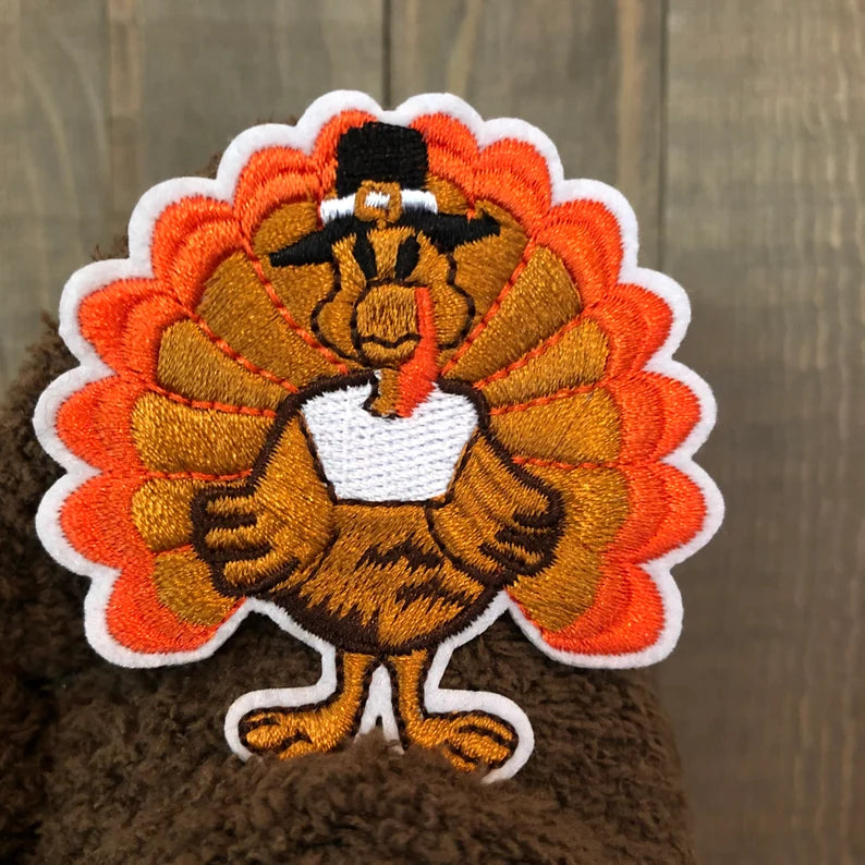 Embroidered patch of a turkey wearing a top hat on a handcraft thanksgiving gnome's head