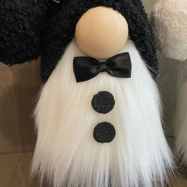 Gnome with a black bow tie and white beard on a blurred background