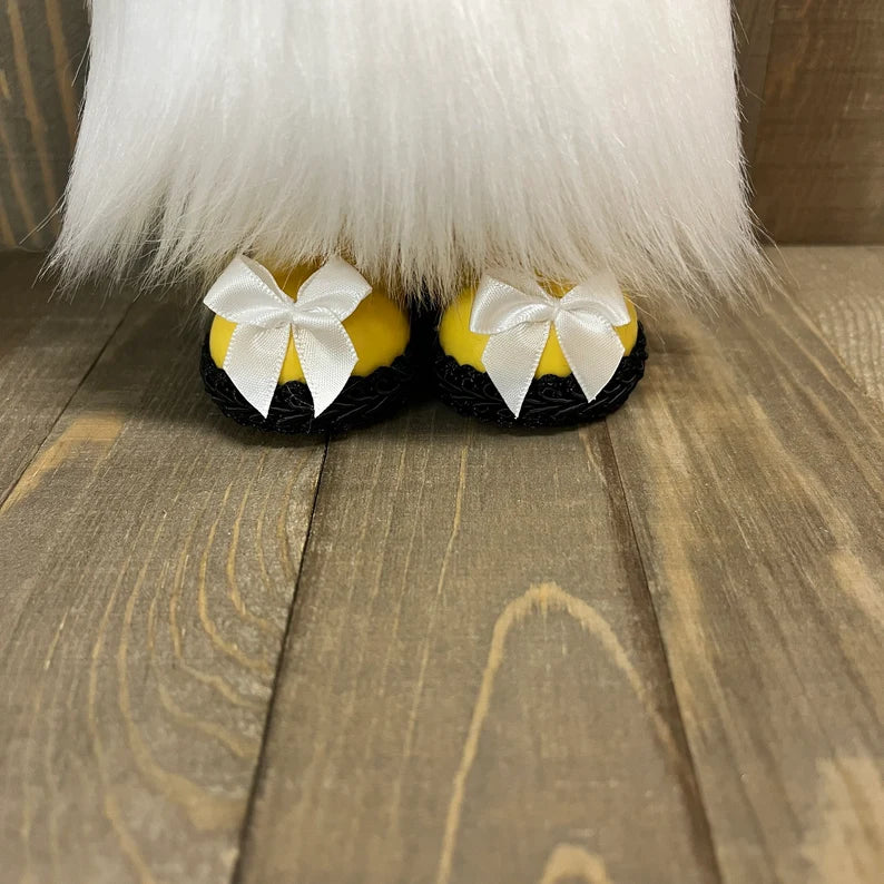 Yellow slippers with white bows on a wooden floor