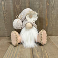 Decorative gnome with a white flower hat on a wooden surface