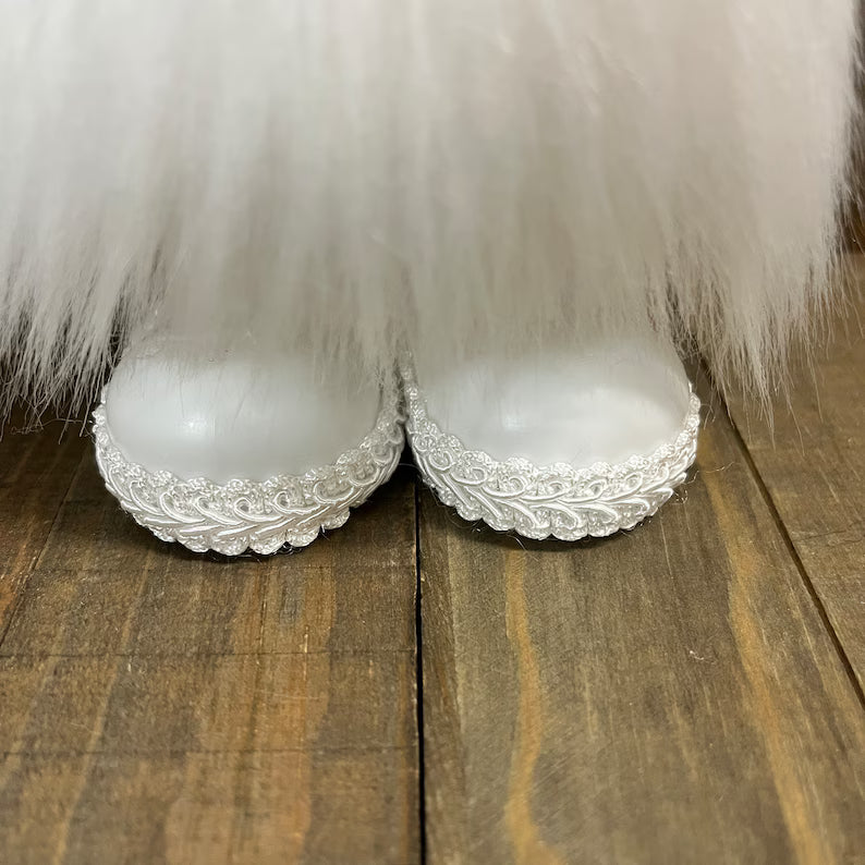 Decorative shoes with lace details on a wooden surface